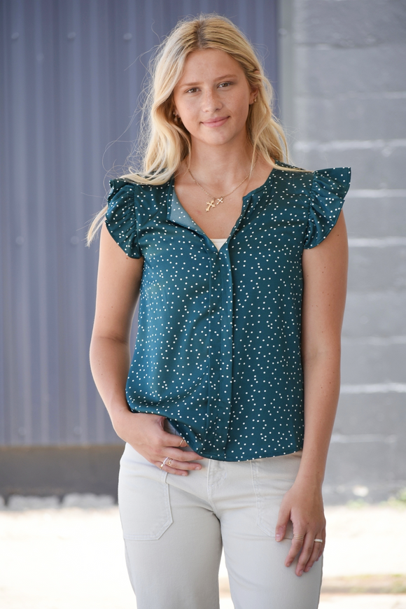 Green blouse with white polka dots, v-neckline, and flutter sleeves